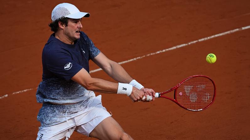 João Fonseca desliza para bater de esquerda contra o tcheco Jakub Mensik em Roland Garros (Foto: Anne-Christine POUJOULAT / AFP)