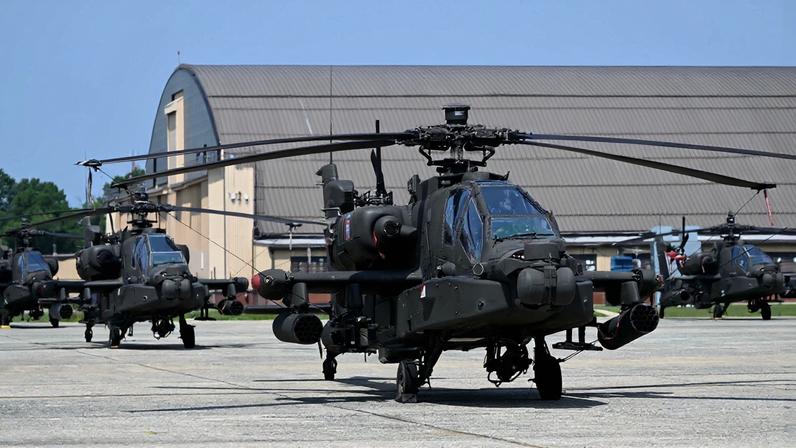 Three AH-64 Apache helicopters line up on a tarmac in Maryland.