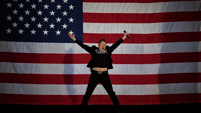 Tesla and SpaceX CEO Elon Musk jumps on stage as he arrives to speak at a town hall event hosted by America PAC in support of former US President and Republican presidential candidate Donald Trump at the Greater Philadelphia Expo Center in Oaks, Pennsylvania, on October 18, 2024.