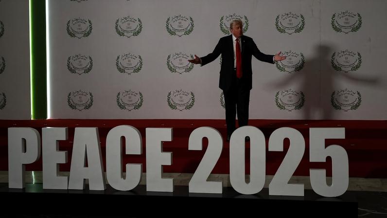 U.S. President Donald Trump gestures as he poses next to a sign at a world leaders' summit on ending the Gaza war, amid a U.S.-brokered prisoner-hostage swap and ceasefire deal between Israel and Hamas, in Sharm el-Sheikh, Egypt, October 13, 2025.