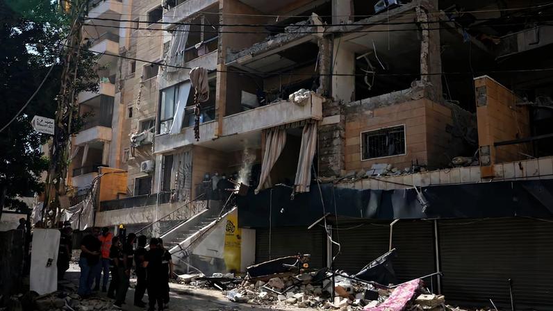 Agentes de seguridad libaneses, junto al edificio golpeado por un bombardeo israelí en Dahiyeh, el suburbio al sur de Beirut, este domingo.