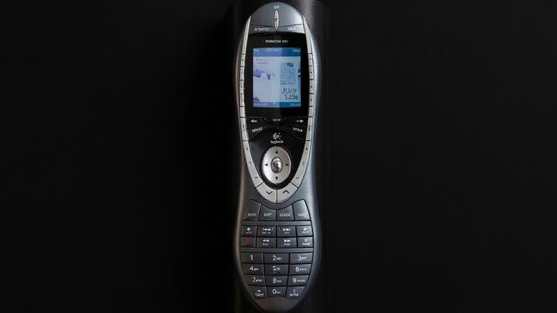 A photo of a silver remote, on its charging cradle.