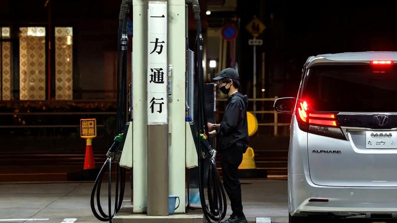 A driver refuels a vehicle at a gas station at night in Tokyo, on May 10.