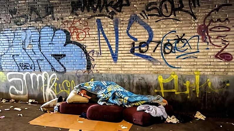 Una persona migrante sin hogar duerme en una estación de tren en Bruselas, en una imagen de archivo