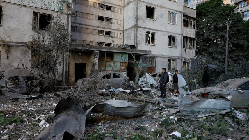 Varias personas inspeccionan los escombros de un edificio tras un ataque ruso, este martes en Kiev.