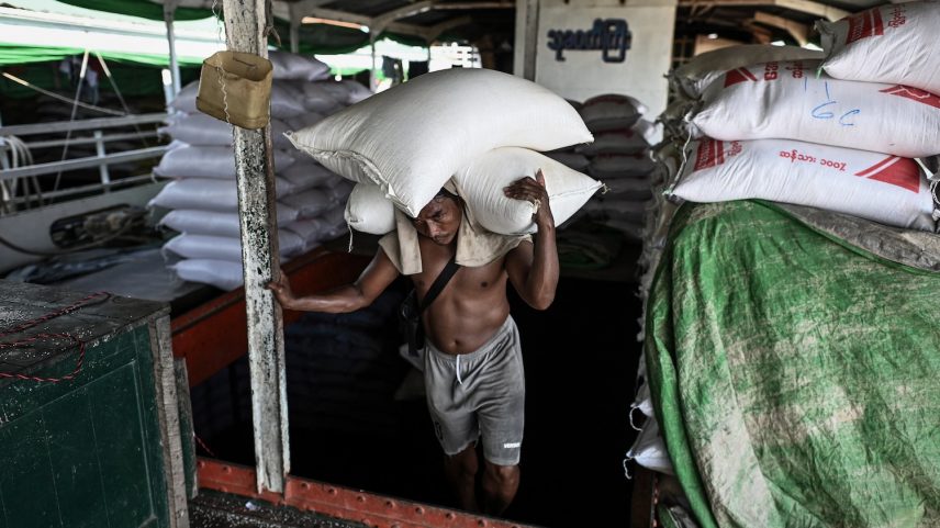 A laborer unloads sacks of rice from a ship in Yangon, Myanmar.