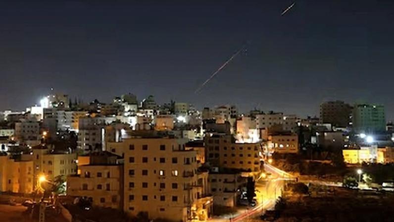 Misiles lanzados desde Irán hacia Israel son vistos en el cielo sobre la ciudad de Hebrón, en Cisjordania, este domingo.