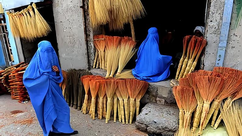 Compradoras afganas buscan escobas en una tienda de carretera en Herat,en enero de 2023.