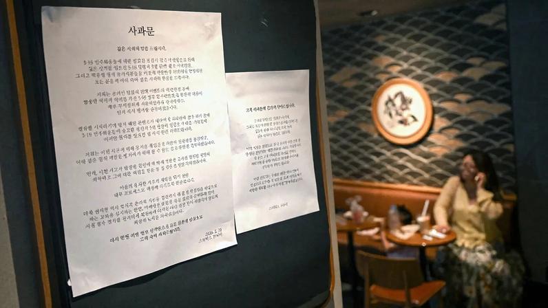An apology notice over a controversial marketing campaign accused of mocking a pro-democracy uprising is posted at a Starbucks store in Seoul on May 26.