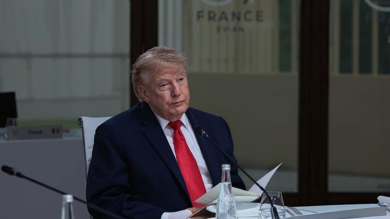 U.S. President Donald Trump sits at a table during a working lunch at the G-7 summit.