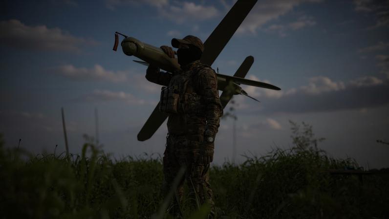 A Ukrainian soldier poses for a photograph with a Bulava strike drone in Ukraine, May 22, 2026.