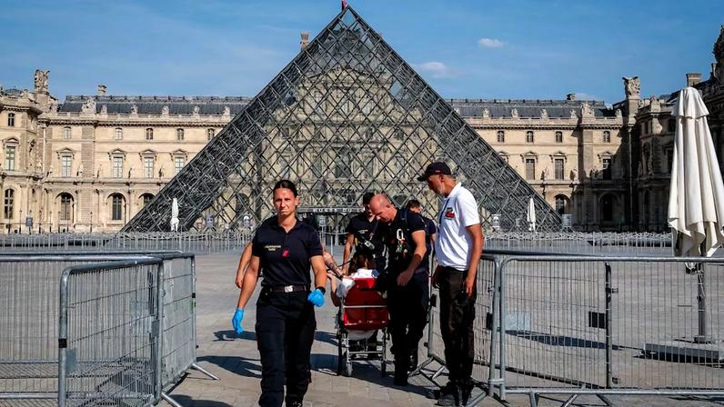Bombeiros escoltam uma pessoa para fora do Museu do Louvre durante uma intensa onda de calor em Paris. Temperaturas na Europa subiram mais que o dobro da média global nos últimos 30 anos.