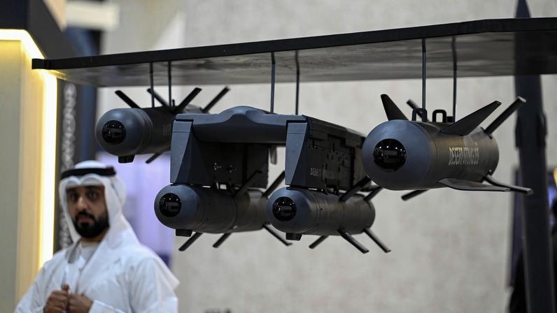 A defense system is on display while a person dressed in white observes in the background.