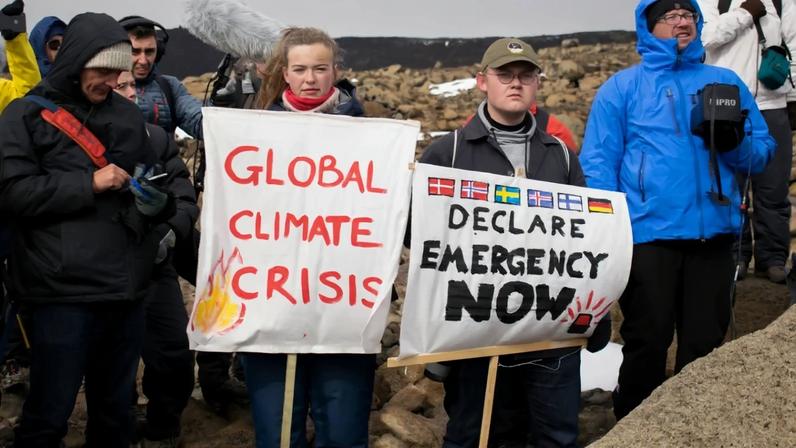 Jovens com placas alertando para a crise climática no planeta (Foto: Jeremie Richard/AFP)