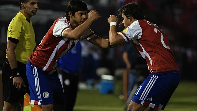 Irmãos Romero frente um ao outro comemorando um gol pela seleção do paraguai.