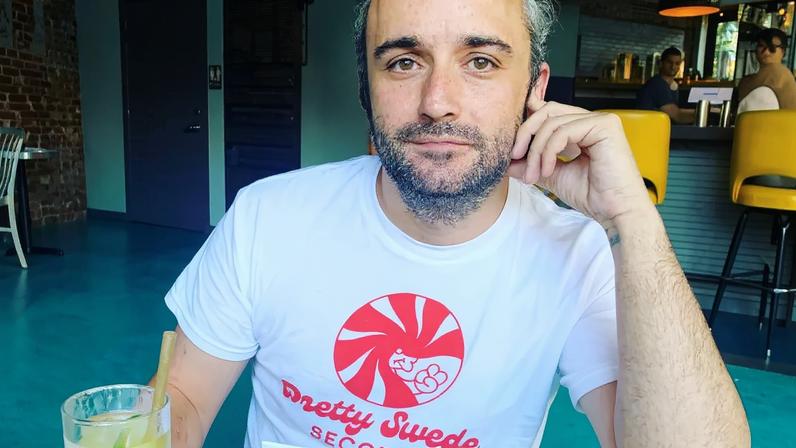 Caleb Willdee, an executive producer for Love Island USA, wearing a white t-shirt with a red "Pretty Swede Records" logo.