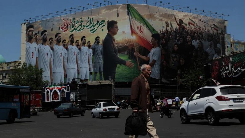 A person walks past a billboard supporting Iran's national men's soccer team in Tehran on May 18.