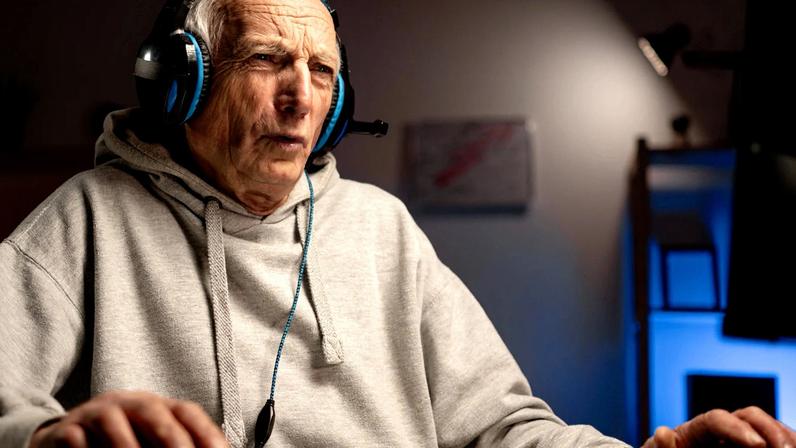 An older gentleman plays on a PC.