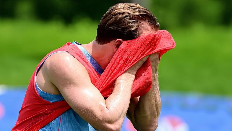 Harry Kane wiping sweat from his face with a training bib