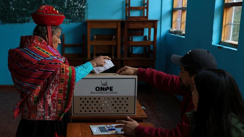 A resident casts her vote during the presidential election runoff at a polling station in Cusco, Peru.