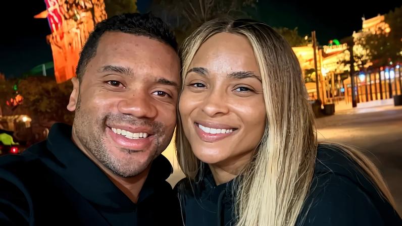 Russell Wilson and Ciara smile together.