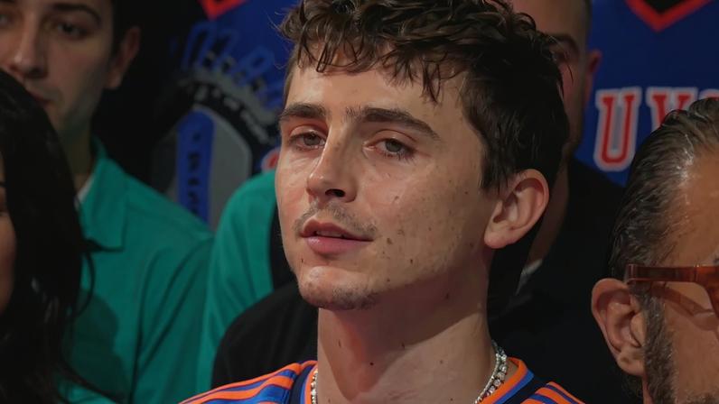 Timothée Chalamet wore a custom diamond “Marty Supreme” pendant by The Crown Collection to the NBA Finals on Wednesday.