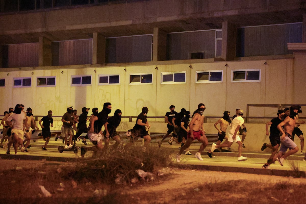 Um grupo de pessoas foge da polícia em Torre Pacheco, este lunes. (Foto: Violeta Santos Moura/REUTERS)