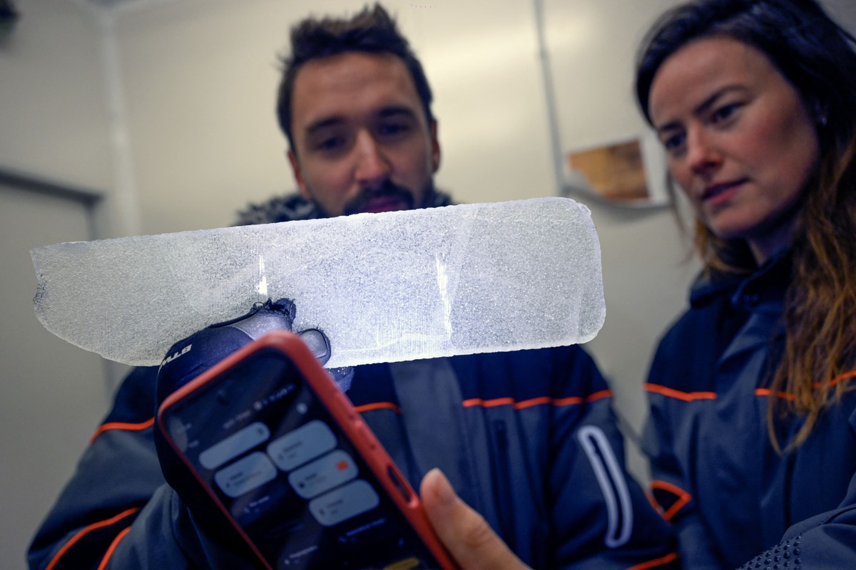 Cientistas belgas observam uma amostra de gelo azul em laboratório (Foto: NICOLAS TUCAT / AFP)
