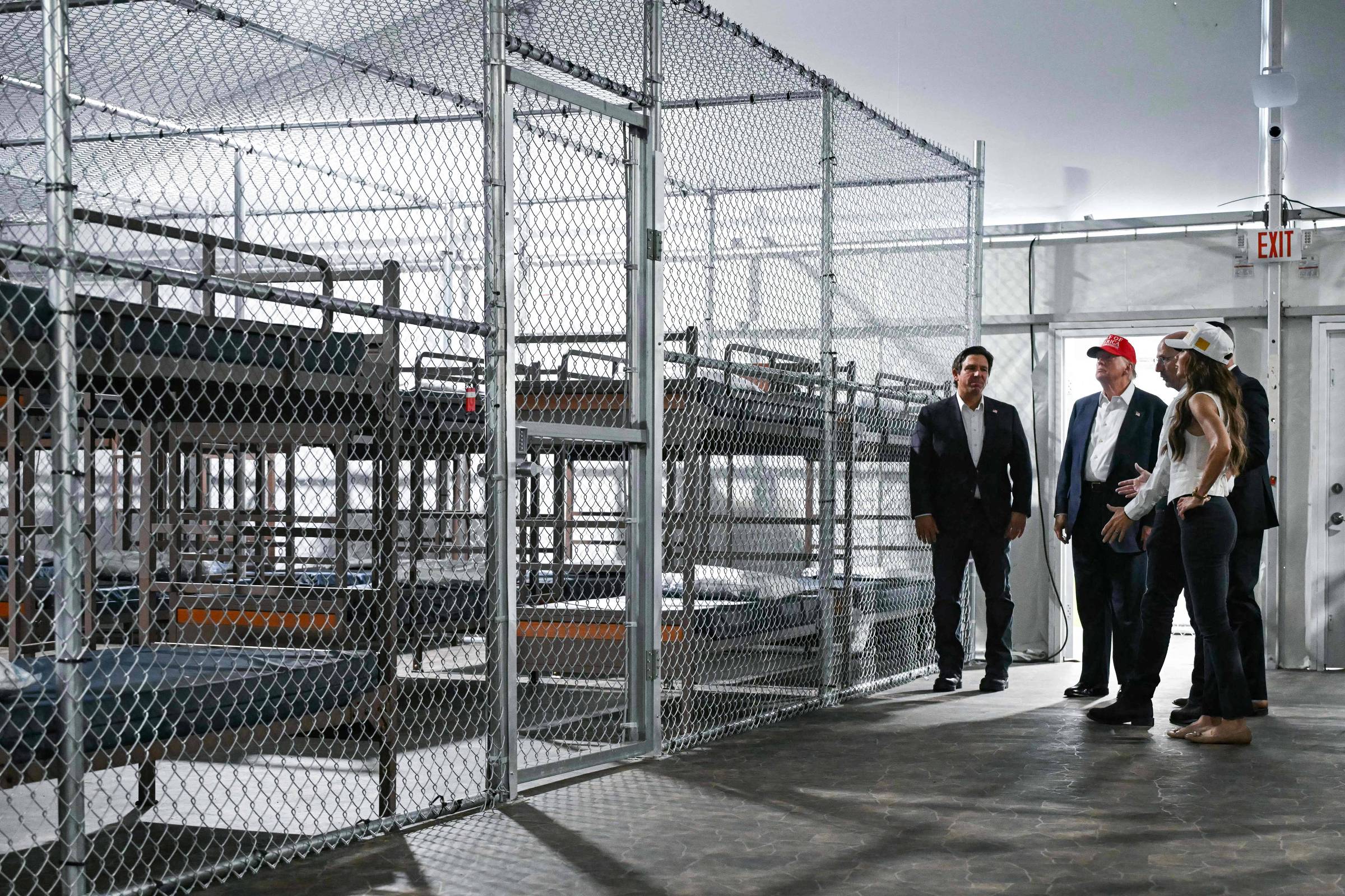 Governo Trump pode aumentar detenção de imigrantes irregulares por anos O presidente dos EUA, Donald Trump, o governador da Flórida, Ron DeSantis, à esquerda, e a secretária de Segurança Interna, Kristi Noem, à direita, visitam um centro de detenção de migrantes apelidado de 'Alcatraz dos jacarés' (Foto: Andrew Caballero-Reynolds - 1º.jul.2025/AFP)