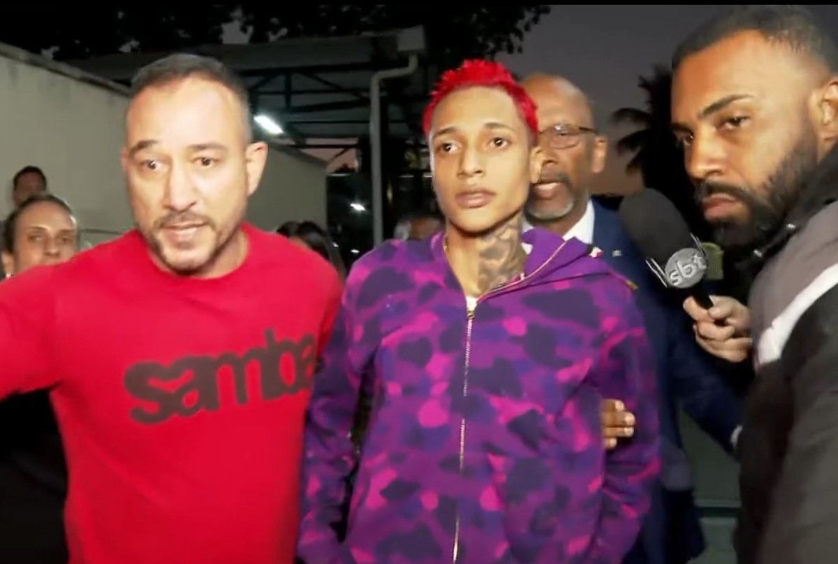 Rapper Oruam permanece preso após decisão judicial e investigações da polícia Oruam chega à Cidade da Polícia (Foto: Reprodução/TV Globo)