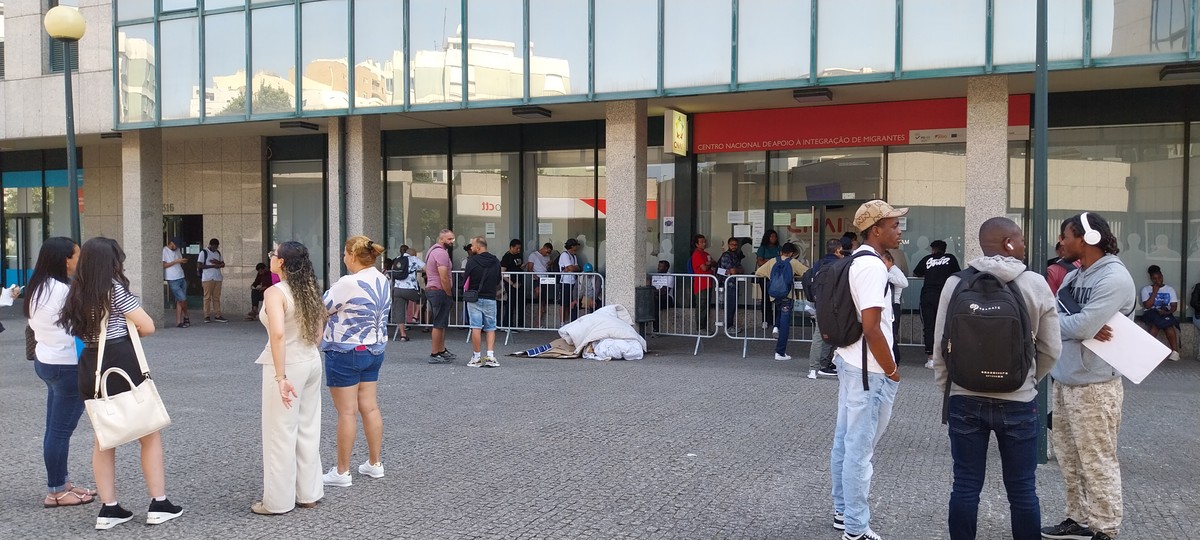 Histórias inéditas revelam narrativas surpreendentes e emocionantes Imigrantes na fila esperam atendimento no Porto em meio aos colchões e lençóis de quem dormiu na fila (Foto: Gian Amato/Portugal Giro/O Globo)